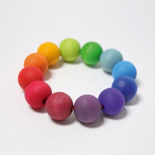Grimms taustes rotaļlieta varavīksnes krāsās